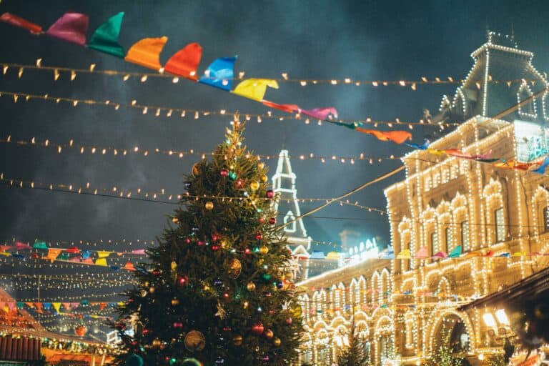 Vibrant Christmas market scene featuring a decorated tree and twinkling lights at night.